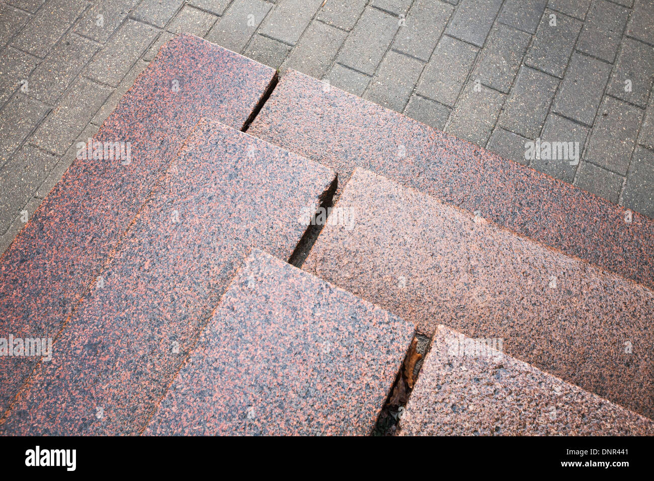 Treppen aus rotem Granit auf grauen Asphalt Stockfoto