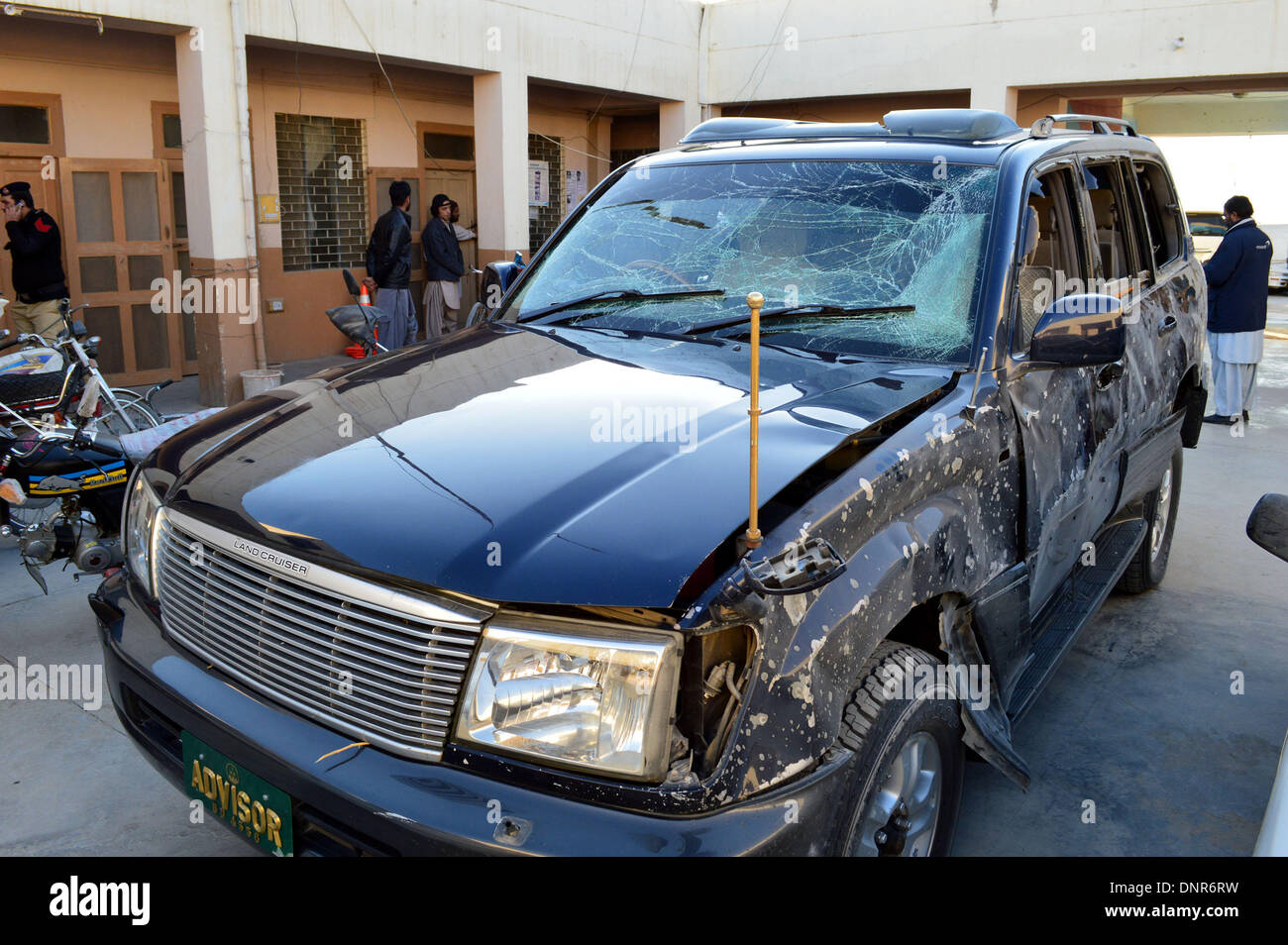 Quetta. 4. Januar 2014. Menschen untersuchen ein beschädigtes Fahrzeug nach einer Explosion im Südwesten Pakistans Quetta, 4. Januar 2014. Mindestens vier Personen einschließlich Berater Hauptminister Balochistan Verletzte in eine Fernbedienung Bombe an der Airport Road in Quetta, lokale Medien berichteten. Bildnachweis: Irfan/Xinhua/Alamy Live-Nachrichten Stockfoto