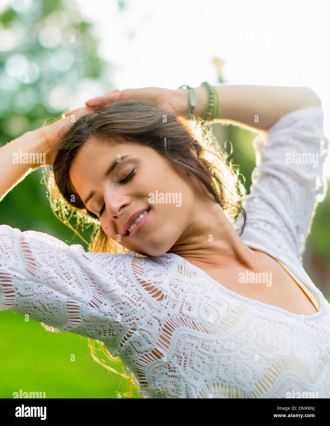 Schöne Frau, die das Licht von einem Sommer Sonnenuntergang genießen Stockfoto