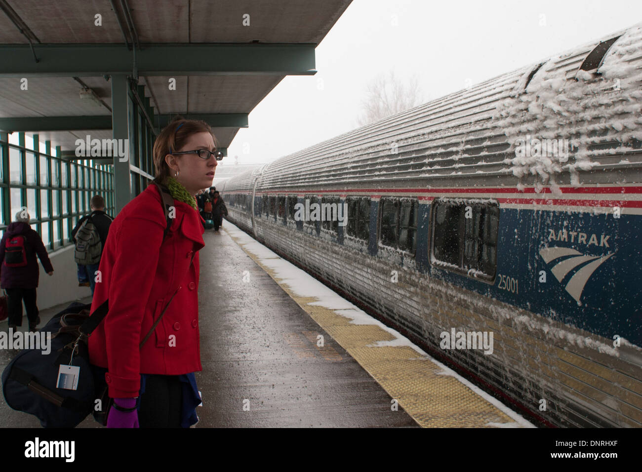 Eine junge Frau wartet einen Amtrak Zug nach Boston an einem verschneiten Wintertag an Bord. Stockfoto