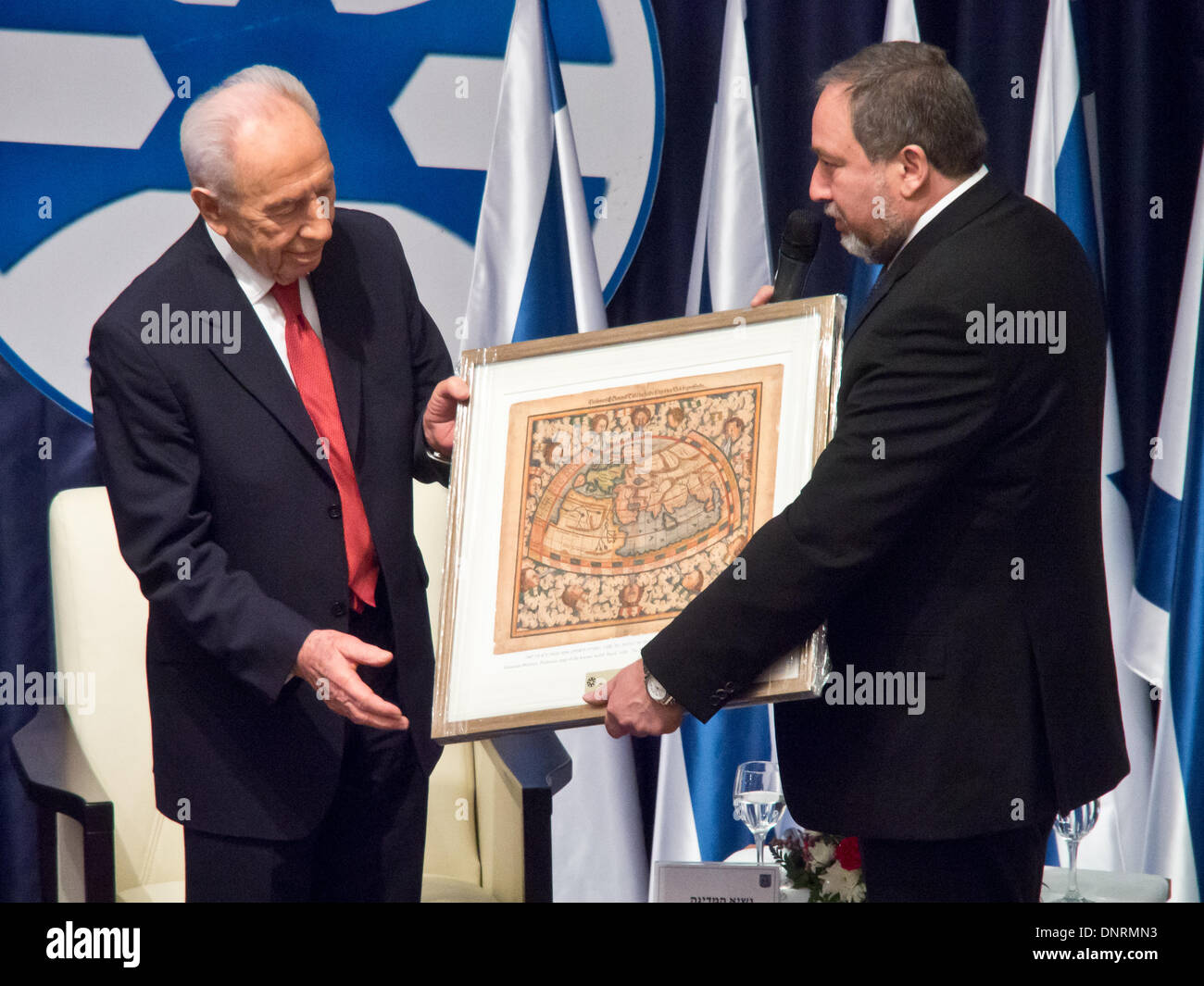 Jerusalem, Israel. 5. Januar 2014. FM, Avigdor Lieberman (R), begrüßt israelischen Präsidenten Shimon Peres (L), und stellt ihn mit einer Karte der Welt; "Du bist hier, am Südpol, und ich bin am Nordpol. Möglichst weit voneinander entfernt, wie möglich, aber wir beide das gleiche wollen ". Jerusalem, Israel. 5. Januar 2014.  Staatspräsident Peres eröffnet der Botschafterkonferenz für Leiter der israelischen diplomatischen Vertretungen weltweit neben Außenminister Lieberman im Ministerium für auswärtige Angelegenheiten. Bildnachweis: Nir Alon/Alamy Live-Nachrichten Stockfoto
