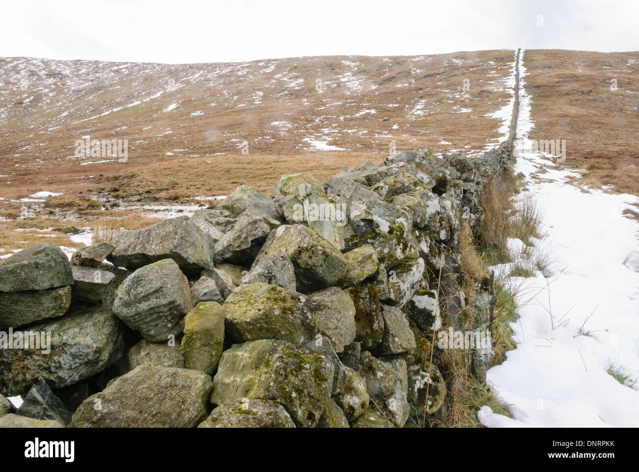 Trockenmauern Wand in den Mourne Berge mit Schnee im Winter. Stockfoto