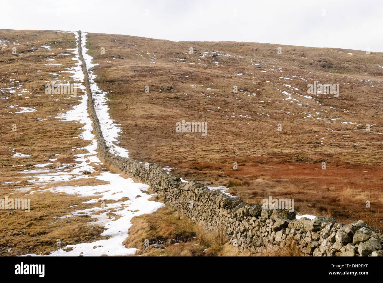 Trockenmauern Wand in den Mourne Berge mit Schnee im Winter. Stockfoto