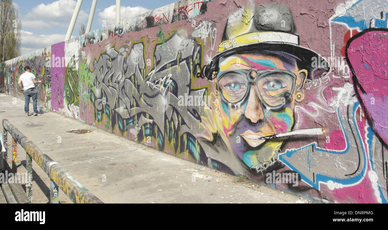 Künstler, die Übermalung Graffiti mit Männerkopf mit Brille, Hut und  qualmender Zigarette, innere Mauer, Mauerpark, Berlin Stockfotografie -  Alamy