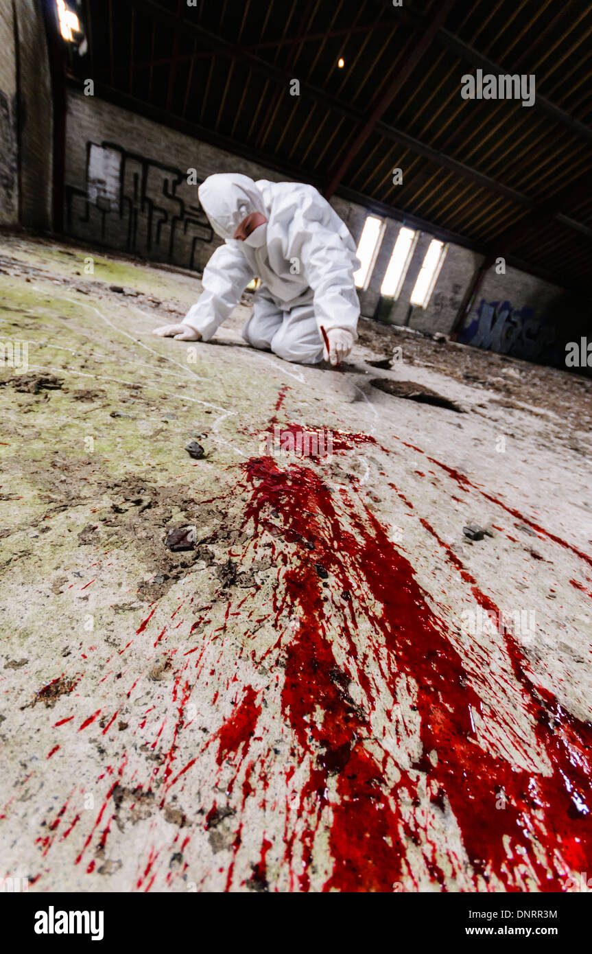 Szene des Verbrechens Officer (SOCO) untersucht eine Gegend um etwas Blut auf dem Boden [industrieübergreifend Modell] Stockfoto