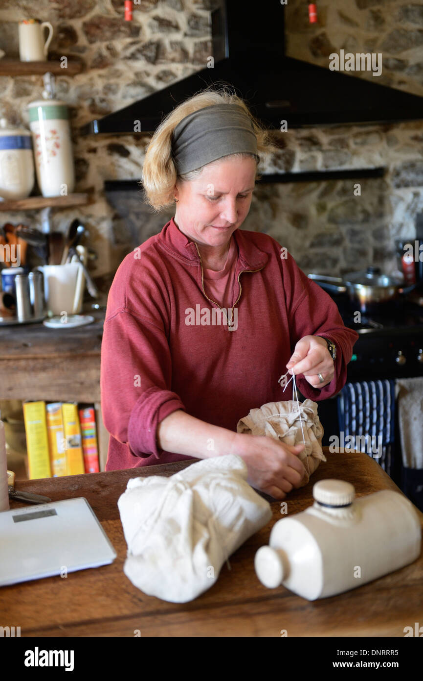 Frau in ihrer Küche ein Schinken-Hock in Musselintuch binden Stockfoto