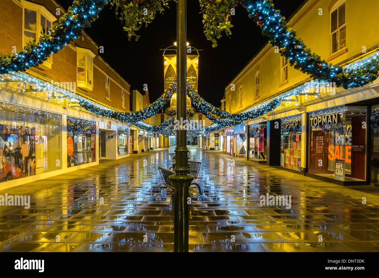 Weihnachtsbeleuchtung in Salisbury. Auf einem nassen kalten Abend mit bunten Reflexionen auf dem Bürgersteig. Stockfoto