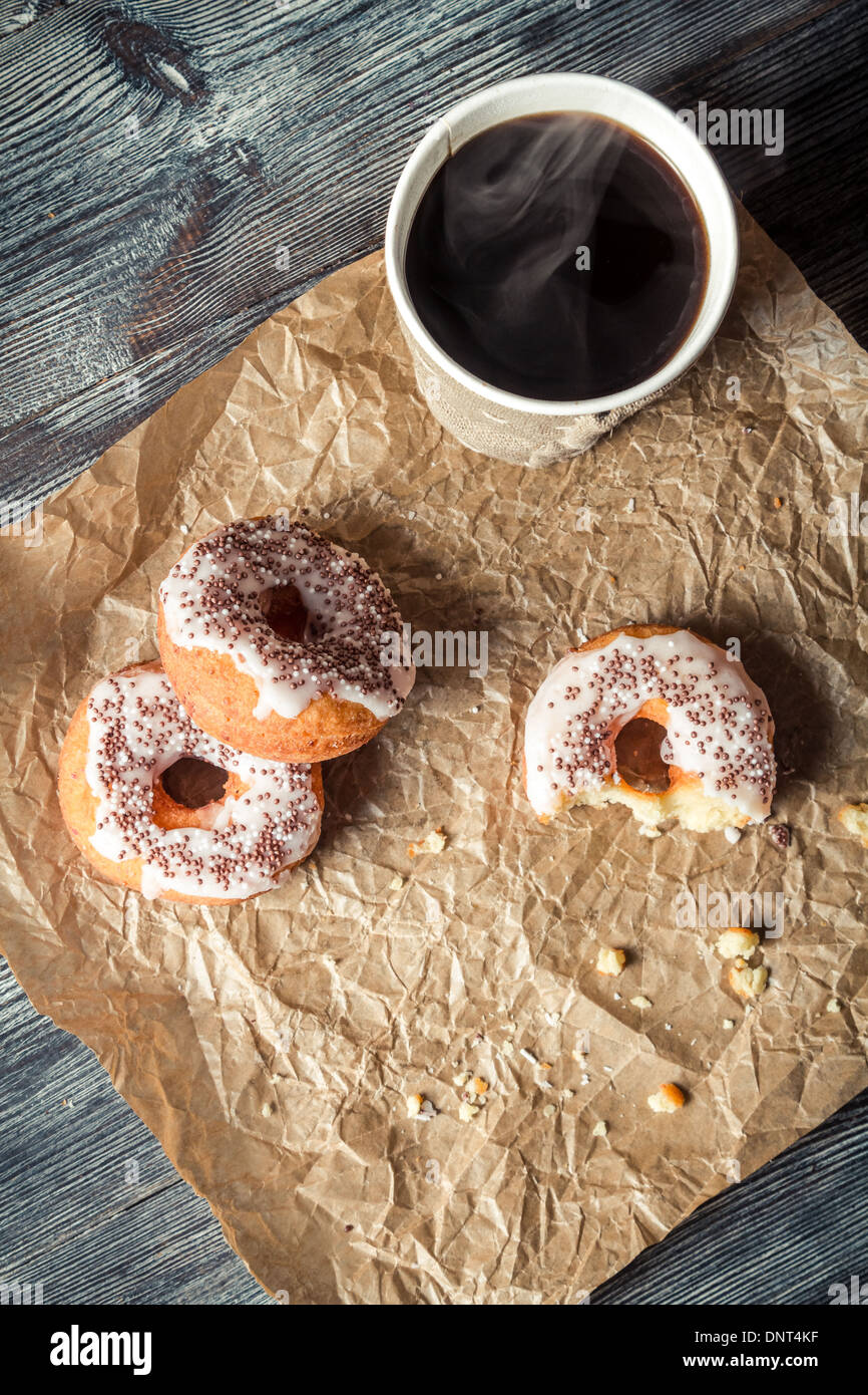 Heißer Kaffee und Donuts in das Papier gegeben Stockfoto