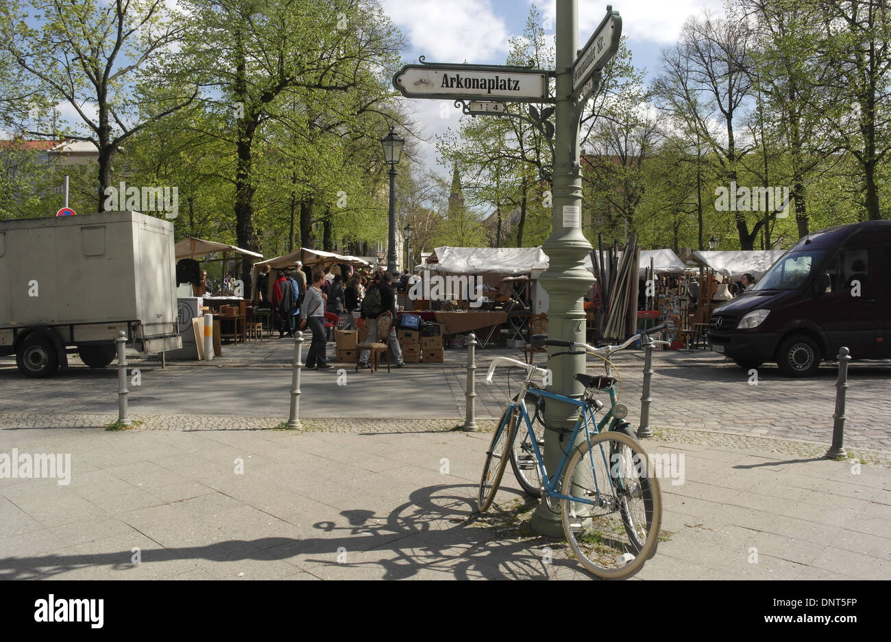 Sonnige Aussicht auf Flohmarkt-Stände, Bäume und Zionskirche, Fahrräder, schiefe Laterne, Arkonaplatz an der Swinemunder Straße, Berlin Stockfoto