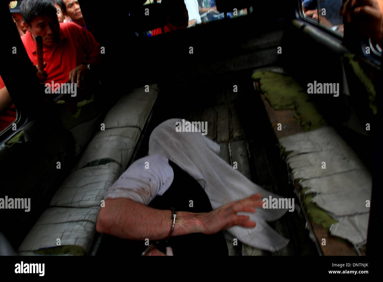 Quezon City, Philippinen. 6. Januar 2014. Ein Geiselnehmer ist in der Rückseite eines LKW geworfen, als er nach der Geiselnahme in Quezon City, Philippinen, 6. Januar 2014 in Polizeigewahrsam genommen wird. Von den Verdächtigen als Geisel genommen wird, für drei Stunden wurden vier Personen, darunter ein Baby verletzt. Bildnachweis: Rouelle Umali/Xinhua/Alamy Live-Nachrichten Stockfoto
