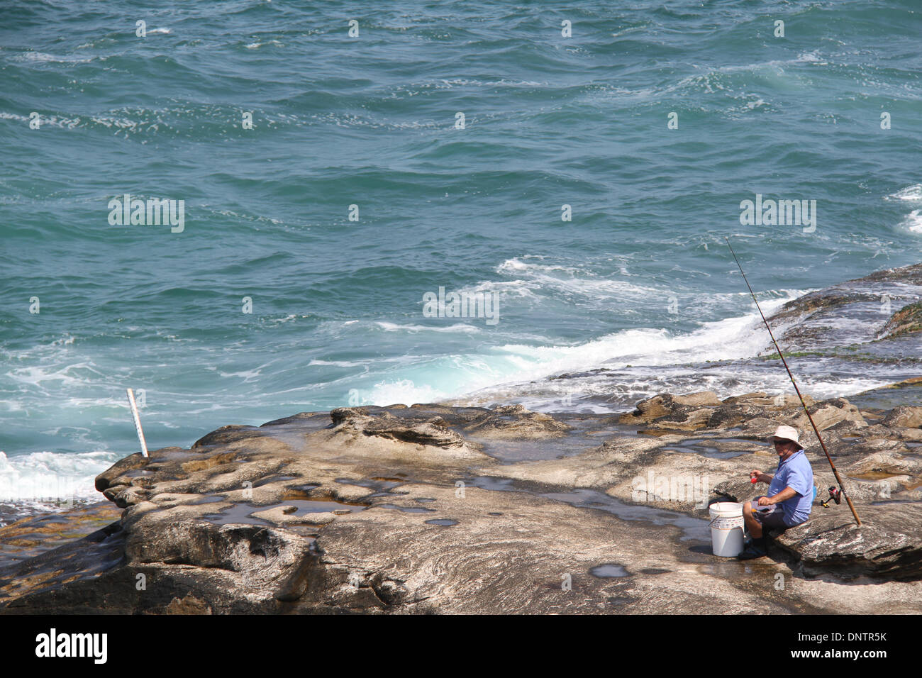 Sydney, NSW, Australien. 5. Januar 2014. Ein Rock-Fischer zwischen Curl Curl Beach und Freshwater Beach an Sydneys Nordstrände. In der Regel bleiben viele Sydneysiders Kopf zu den vielen Stränden rund um Sydney am Wochenende, wo Surf lebensrettende freiwillige machen Sie sicher, dass sie gesund. Copyright Credit: 2014 Richard Milnes/Alamy Live-Nachrichten Stockfoto