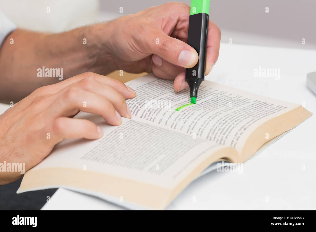 Hände, hervorheben von Text im Buch auf dem Tisch Stockfoto