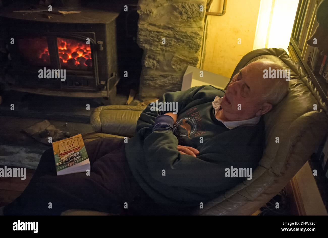 Ein Mann in den 70er schlafend auf einem Stuhl nach dem Abendessen. Stockfoto