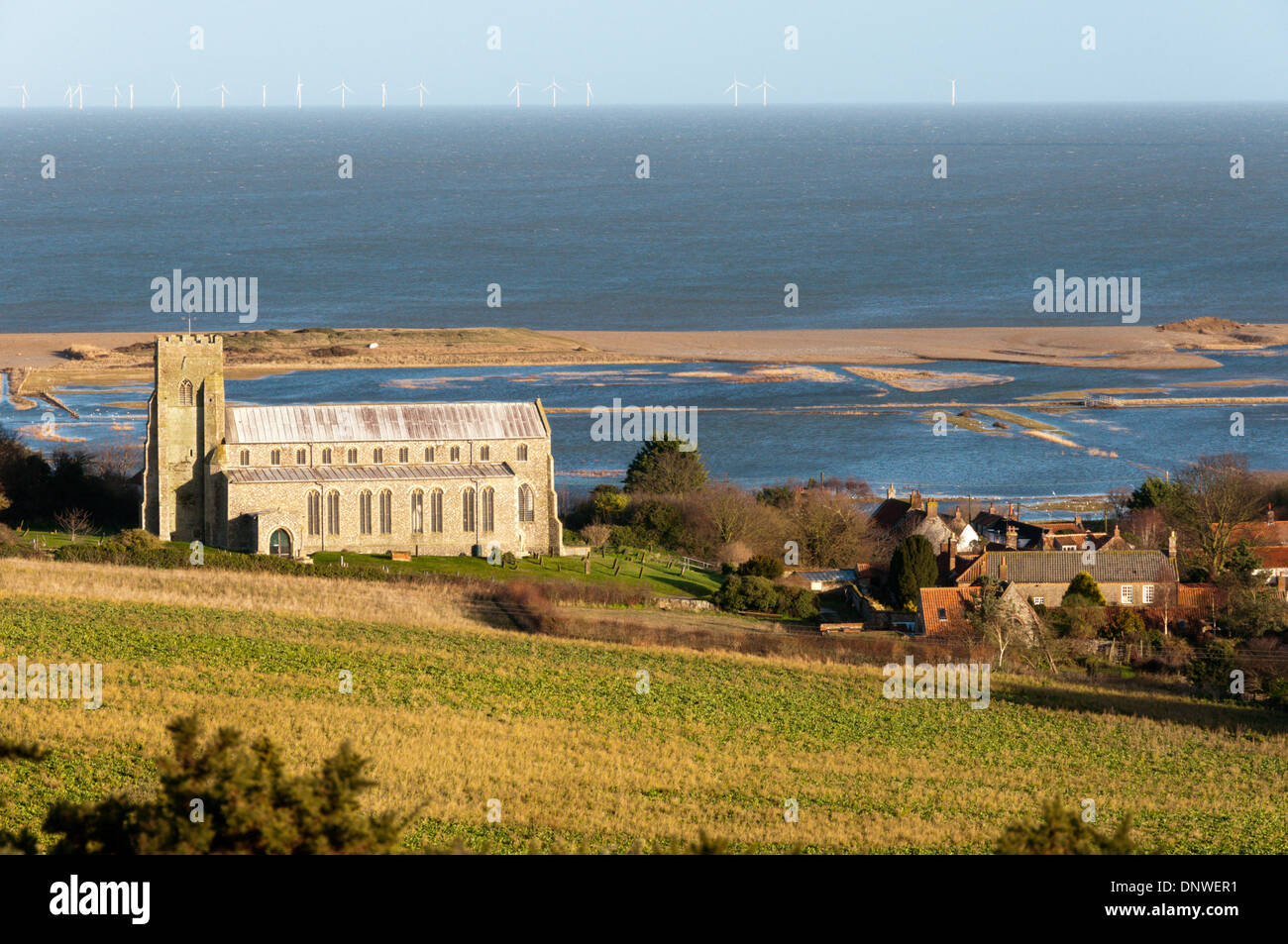 Salthouse St.-Nikolaus-Kirche vor überflutet wurden mit Sheringham Shoal Windpark am Horizont. Stockfoto