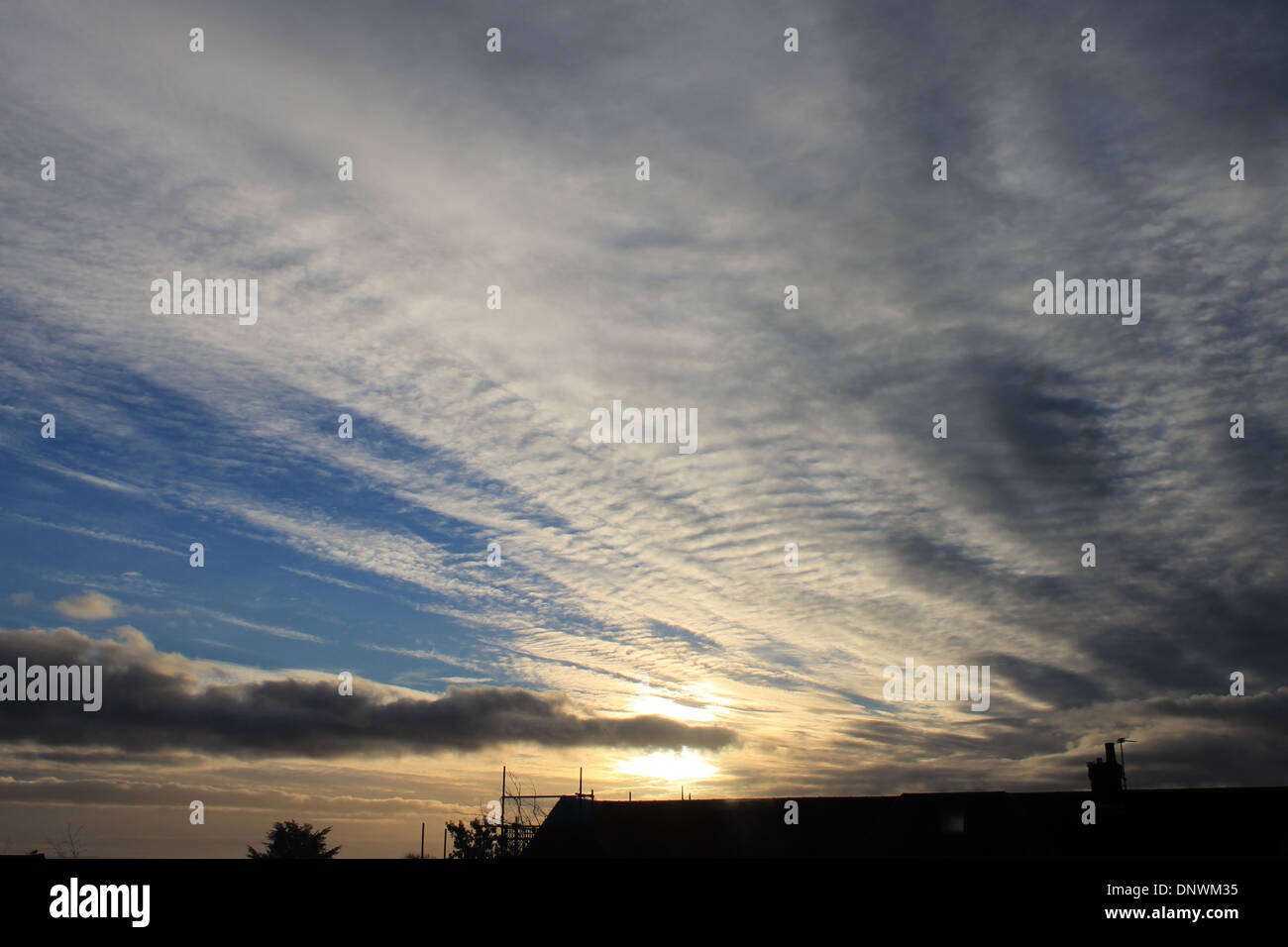 Interessante Cirrus, Cumulus und Cirrocumulus Wolke Formationen bei Sonnenaufgang an einem Wintermorgen in Hampshire, UK Stockfoto