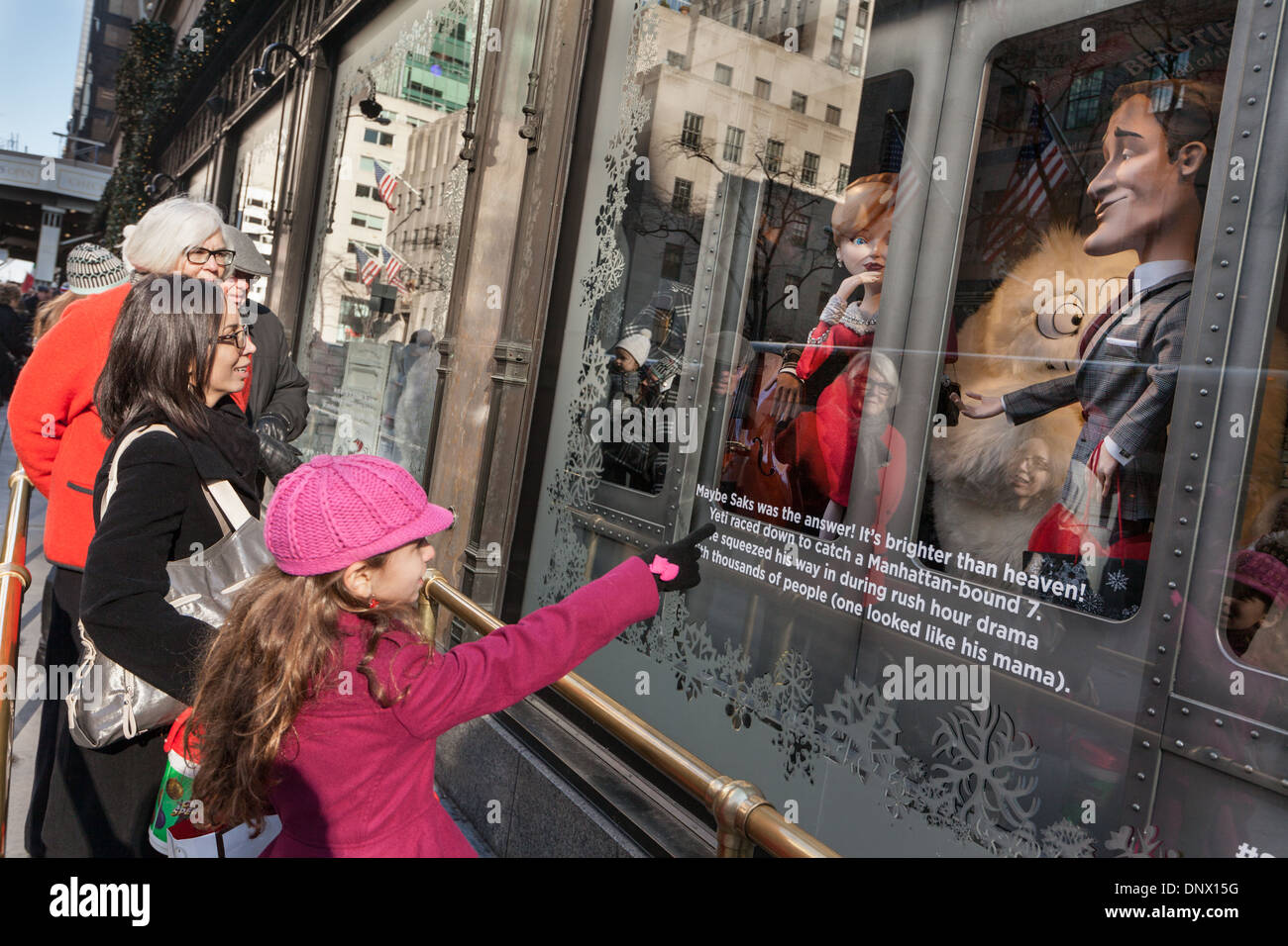 Kinder und Eltern bestaunen Weihnachtsfenster, Saks Fifth Avenue, New York City. Stockfoto