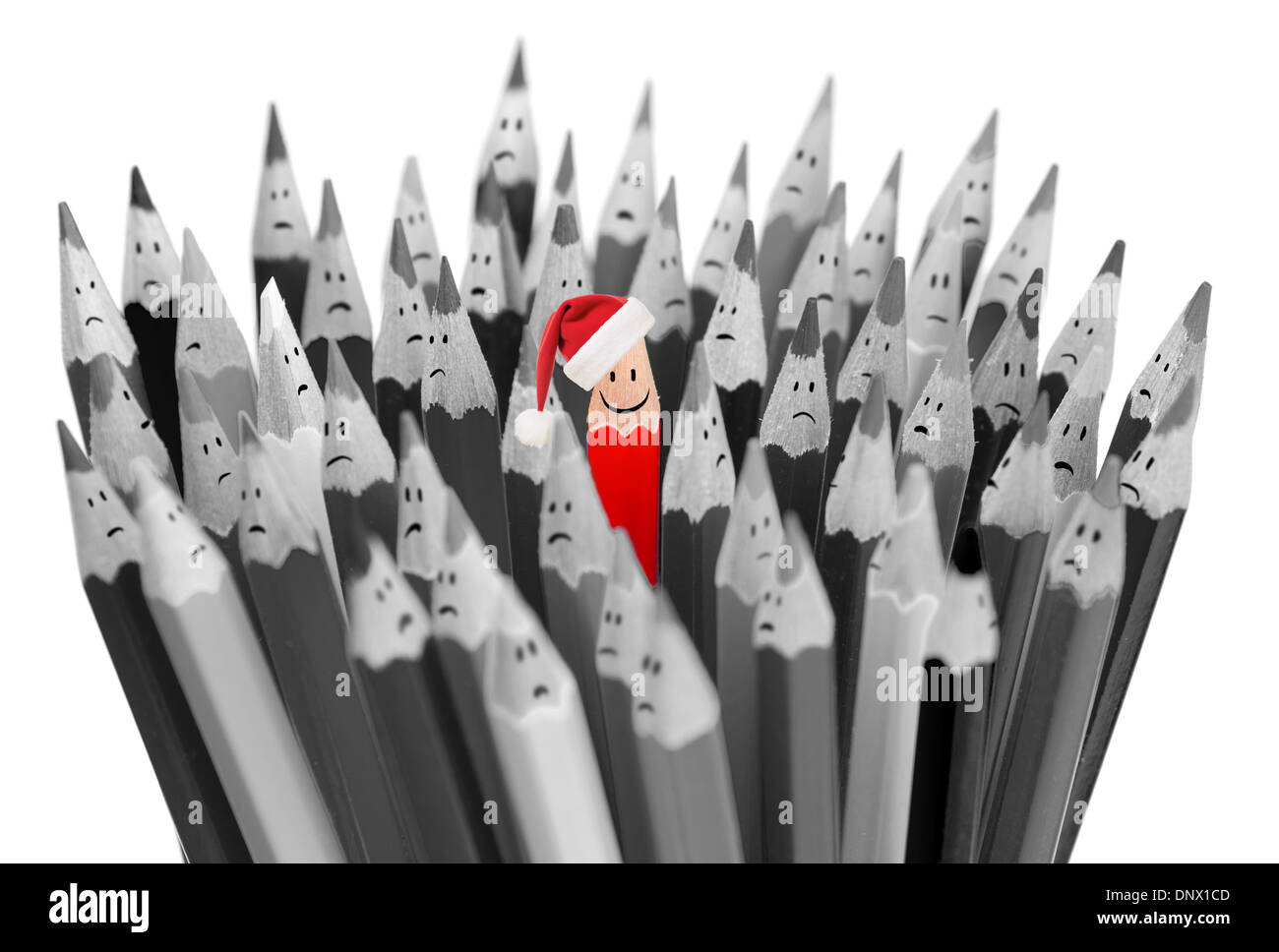 Bleistift mit Lächeln in Nikolausmütze unter traurig grauen Stifte Weihnachten Stockfoto