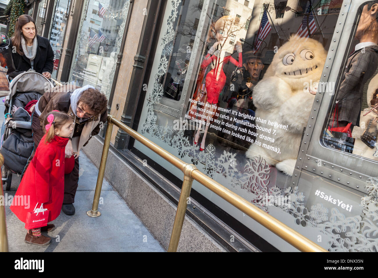 Kinder und Eltern bestaunen Weihnachtsfenster, Saks Fifth Avenue, New York City. Stockfoto