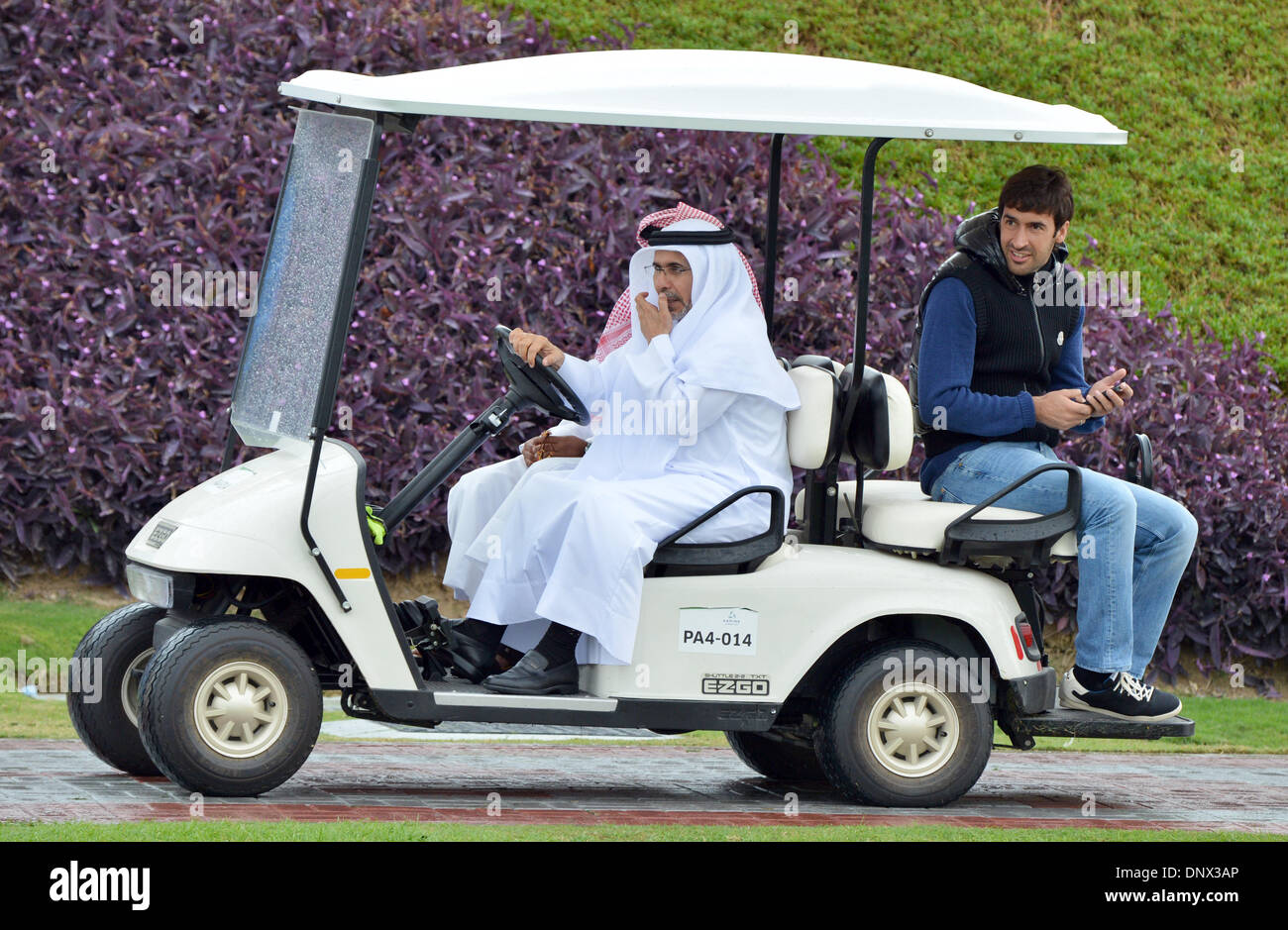 Doha, Katar. 6. Januar 2014. Ehemalige Schalke-Profi-Spieler Raul Gonzalez (R) treibt über das Trainingsgelände des FC Bayern München in einem Caddy Auto in Doha, Katar, 6. Januar 2014. Das Trainingslager in Katar dauert bis zum 13. Januar 2014. Foto: Peter Kneffel/Dpa/Alamy Live News Stockfoto