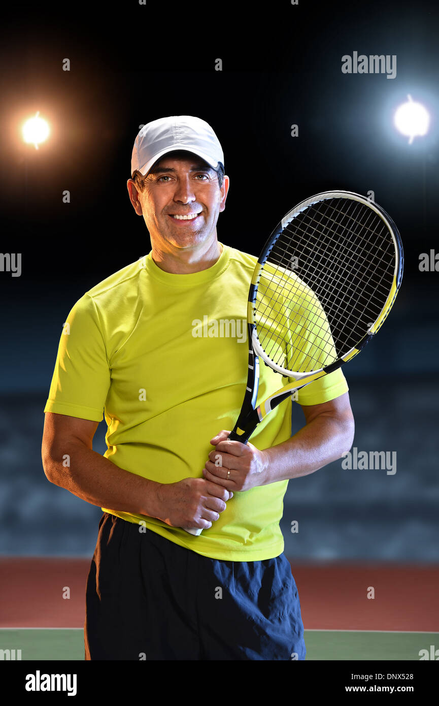 Porträt von Hispanic senior Spieler Schläger stehen auf Tennisplatz Stockfoto