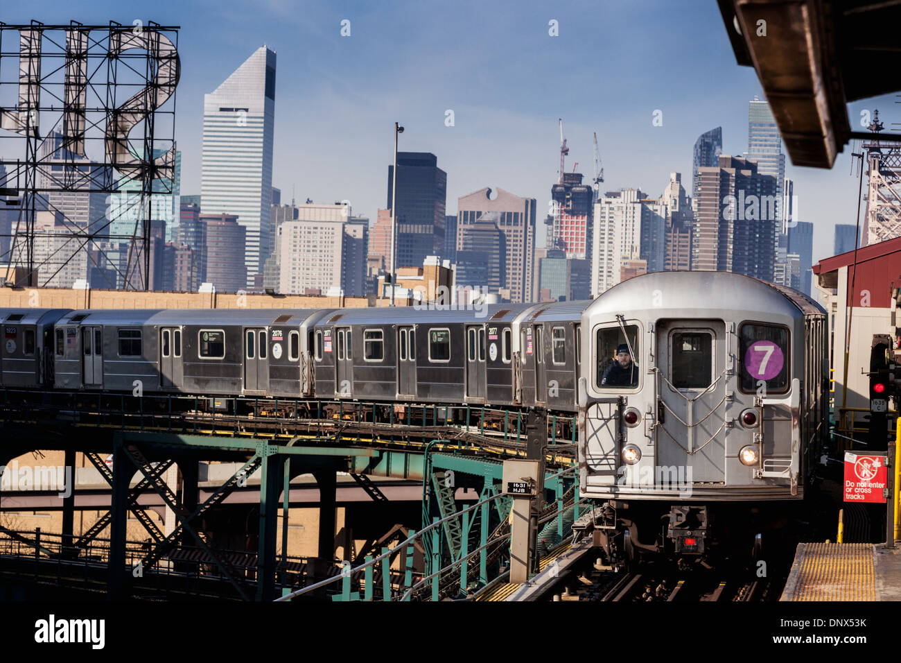 Nummer sieben 7 Zug, Spülen gebunden ist, kommt an einem Bahnhof in Queens, New York City, USA. Stockfoto