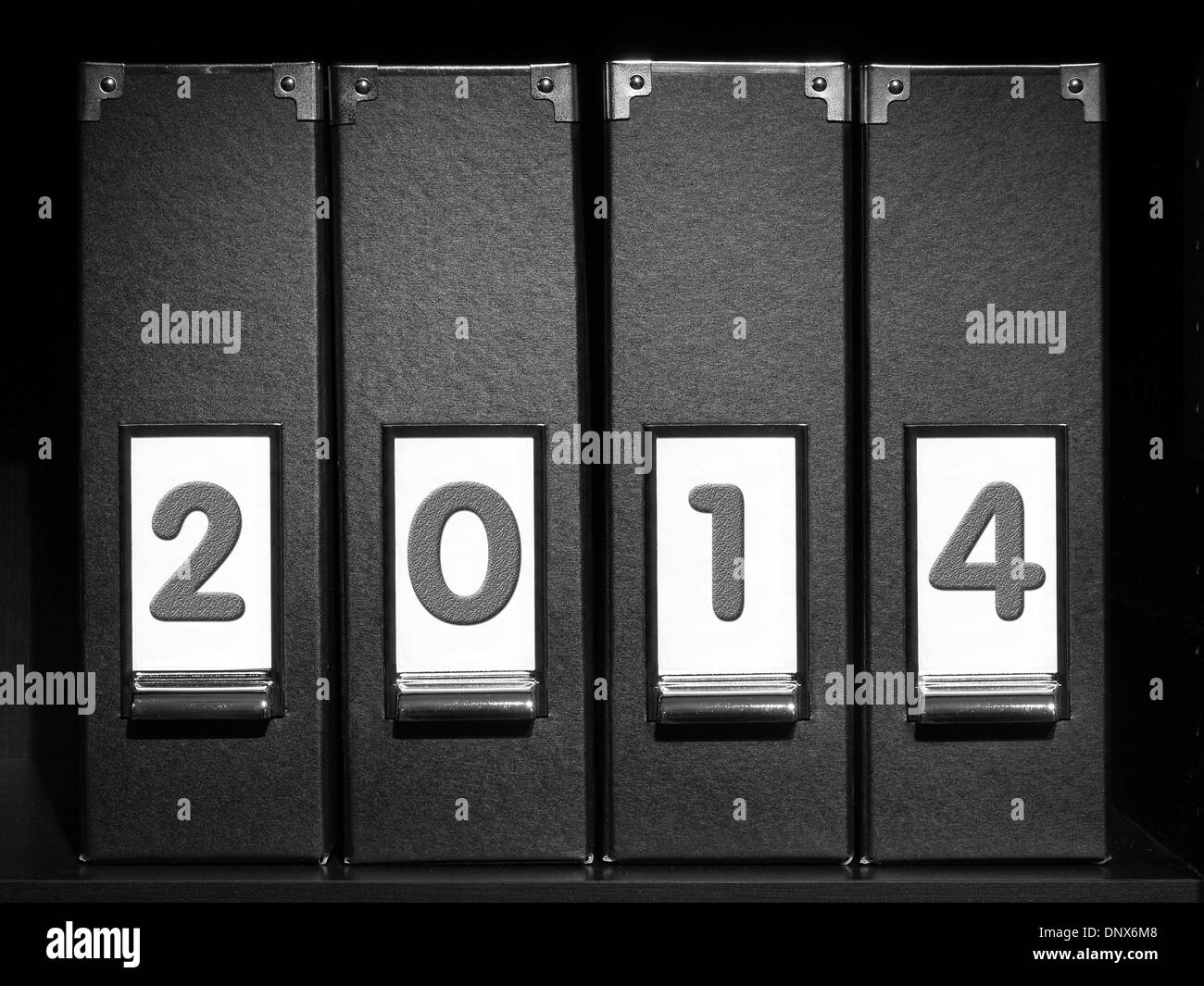 Vier schwarze Bindemittel mit Neujahr 2014 stellen platziert auf Bücherregal Stockfoto