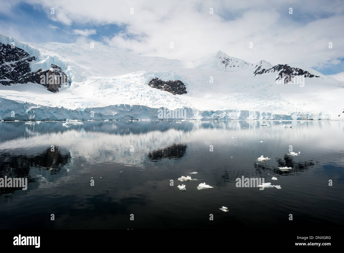 Antarktis - Das eisige und felsigen Landschaft Berge in Eis und Schnee bei Neko Harbour auf der Antarktischen Halbinsel abgedeckt ist auf Glasigen Spiegel reflektiert - wie ruhiges Wasser. Stockfoto