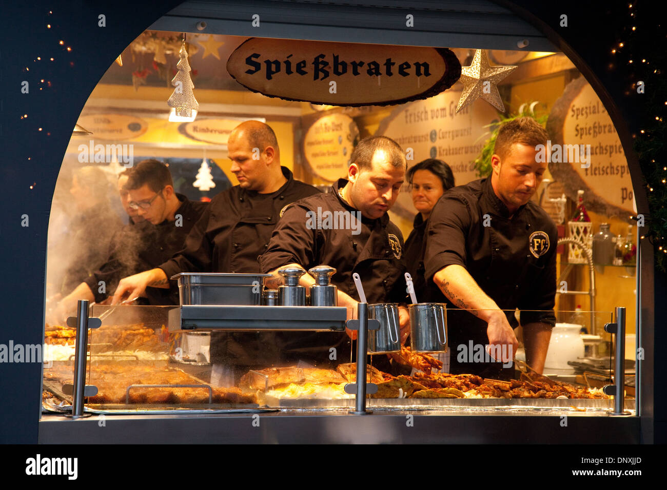 Deutsche Weihnachtsmärkte Spiessbraten (Schweinefleisch Steaks) gekocht wird auf einem Stall in der Kathedrale Markt, Cologne (Köln), Deutschland Stockfoto