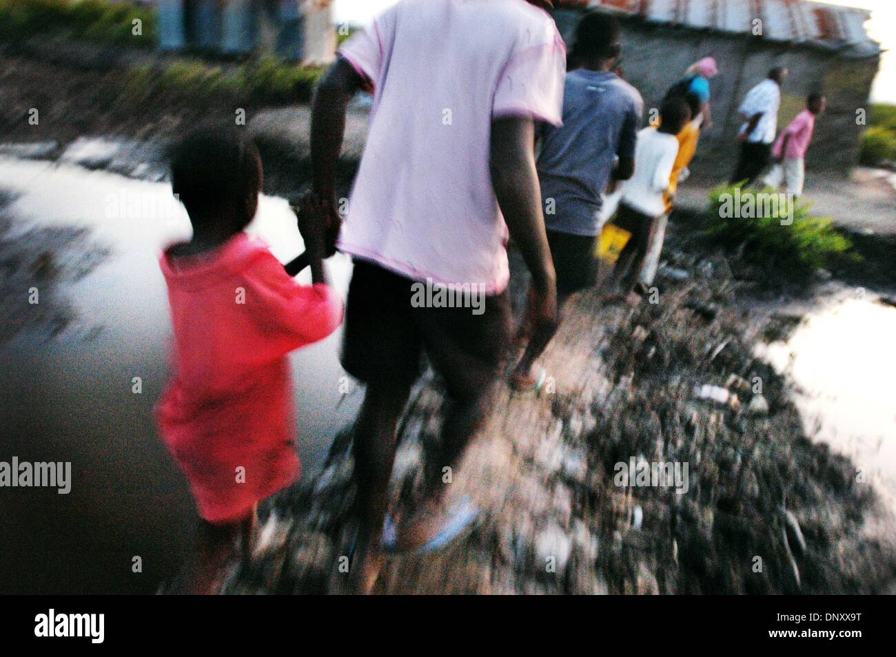 7. März 2006 sagen - Cap-Haitien, Haiti - Bewohner, dass der Bereich ernst mehrmals im Jahr Überschwemmungen und sie Geschichten erzählen tragen ihre Kinder durch brusttiefen Wasser, blind für die Sicherheit auf dem Schwarz der Nacht durch Anschluss an ihre Nachbarn Stimmen geführt. Auch in der Dämmerung sind die kaum erhöhten Wege durch den Sumpf rutschig und schwer zu verhandeln. (Kredit-Bild: © Benja Stockfoto