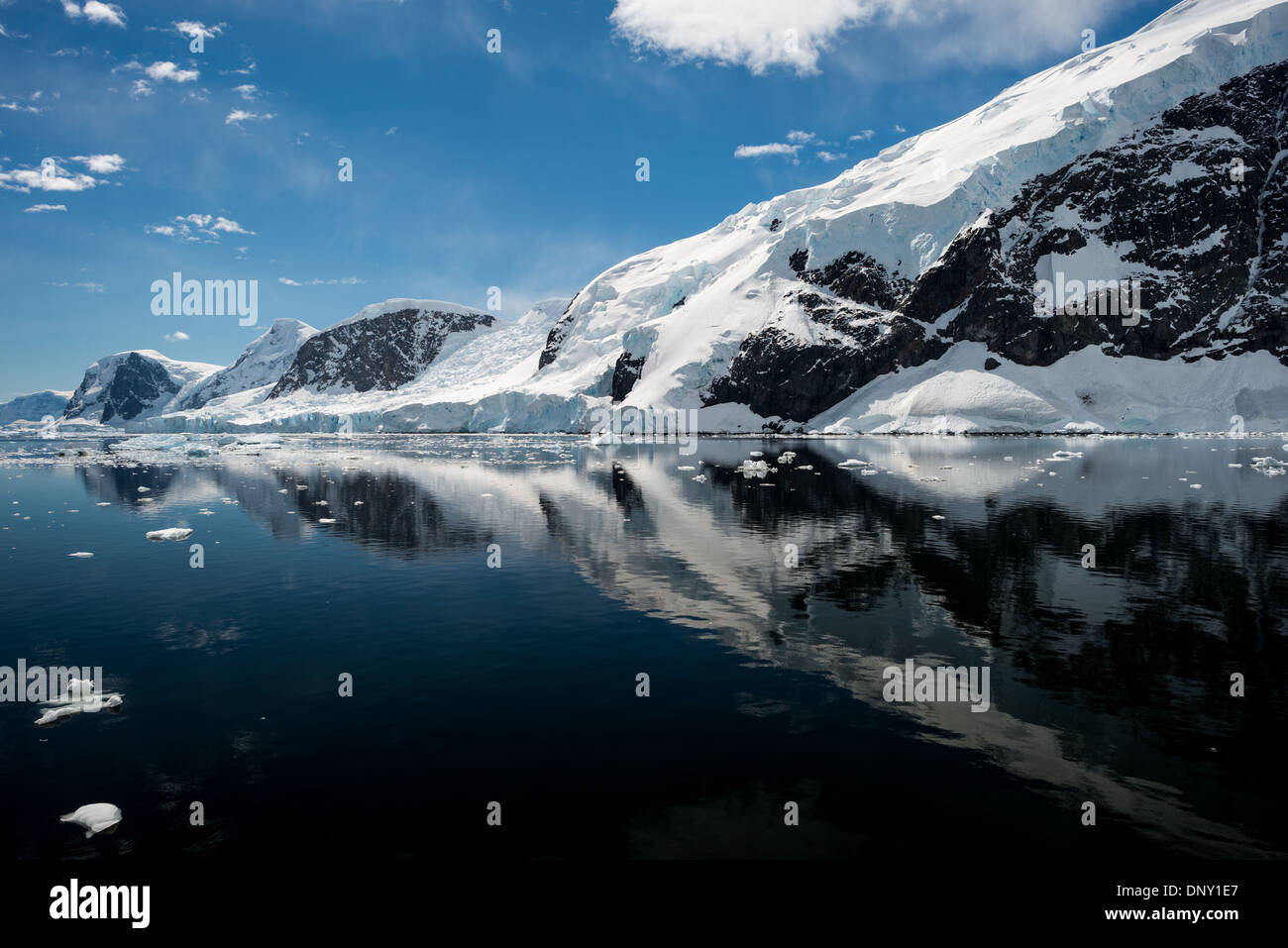 Antarktis - Das eisige und felsigen Landschaft Berge in Eis und Schnee bei Neko Harbour auf der Antarktischen Halbinsel abgedeckt ist auf Glasigen Spiegel reflektiert - wie ruhiges Wasser. Stockfoto