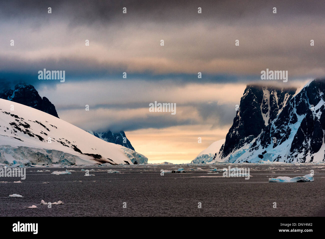 Lemaire Channel Landscape Antarctica // LEMAIRE CHANNEL, Antarktis — die malerische Landschaft des Lemaire Channel, mit steilen Bergklippen, die auf beiden Seiten aus dem Wasser ragen und dem Glühen der frühen Morgensonne in der Ferne. Der Lemaire Channel wird manchmal als „Kodak Gap“ bezeichnet, um an seine berühmte malerische Aussicht zu erinnern. Stockfoto