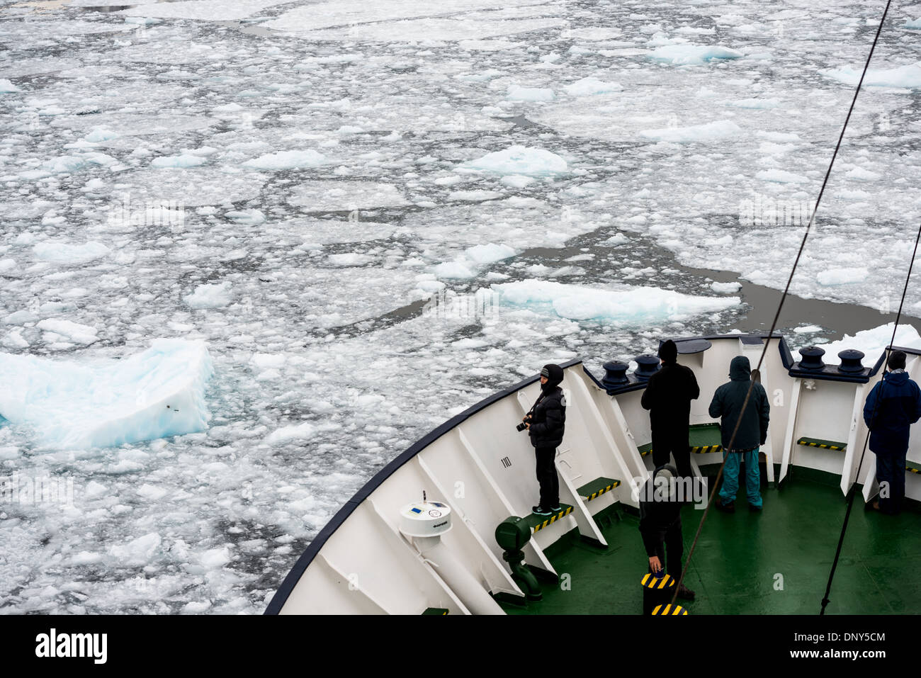 Antarktis - Fahrgäste stehen auf dem Bug eines ice-gestärkt Antarktis Kreuzfahrt Schiff wie Sie navigiert die engen Lemaire Kanal auf der westlichen Seite der Antarktischen Halbinsel. Die Lemaire Kanal wird manchmal auch als "Kodak Lücke' in einem Kopfnicken zu seiner berühmt malerische Aussicht bezeichnet. Stockfoto