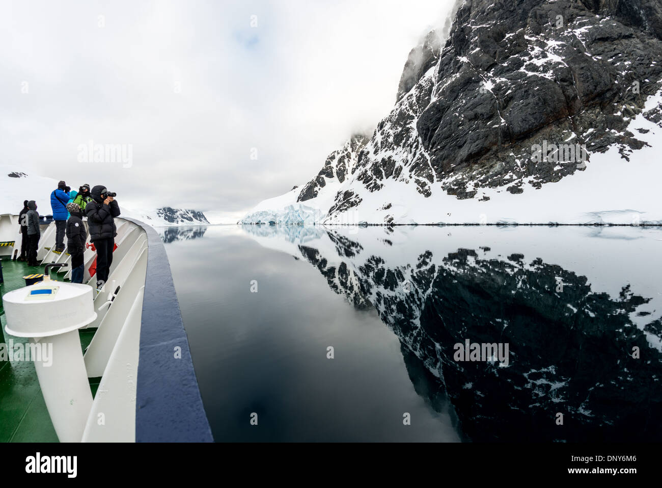 Lemaire Channel Reflections Antarktis // LEMAIRE CHANNEL, Antarktis — perfekte spiegelähnliche Reflexionen der Berge und Klippen am Glandaz Point auf Booth Island schaffen eine symmetrische Szene in den ungewöhnlich ruhigen Gewässern. Diese glasartigen Bedingungen im Lemaire-Kanal, auch „Kodak Gap“ genannt, sind selten in dieser typisch windgepeitschten Region der Antarktischen Halbinsel. Die stillen Gewässer bilden einen natürlichen Spiegel der dramatischen antarktischen Landschaft. Stockfoto