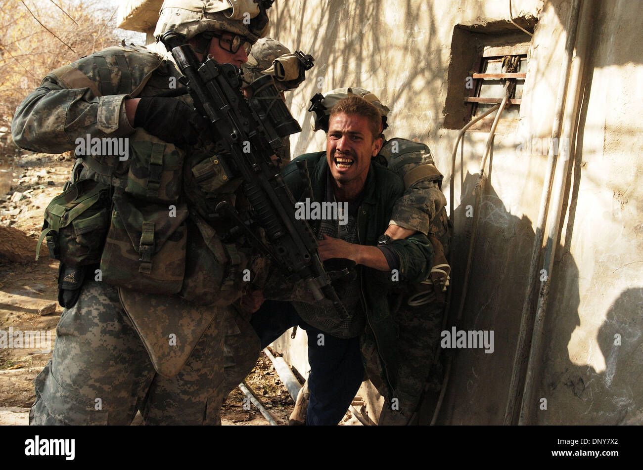 17. Januar 2006; Abu Ghraib, Bagdad, Irak; Infanteristen aus Co. A, 1. der 87. Infanterie, suchen ein Bauerndorf 17. Januar 2006, Waffenlager. Sie fand ein paar Ak-47 Gewehre und Munition in den Häusern. Einer der Abschnitte gefunden ein paar Munition Patronengürtel in Eimern begraben in einem Feld. Ein geistig behinderter Mann reagiert auf seine Haft durch amerikanische Infanteristen. Der Mann walke Stockfoto