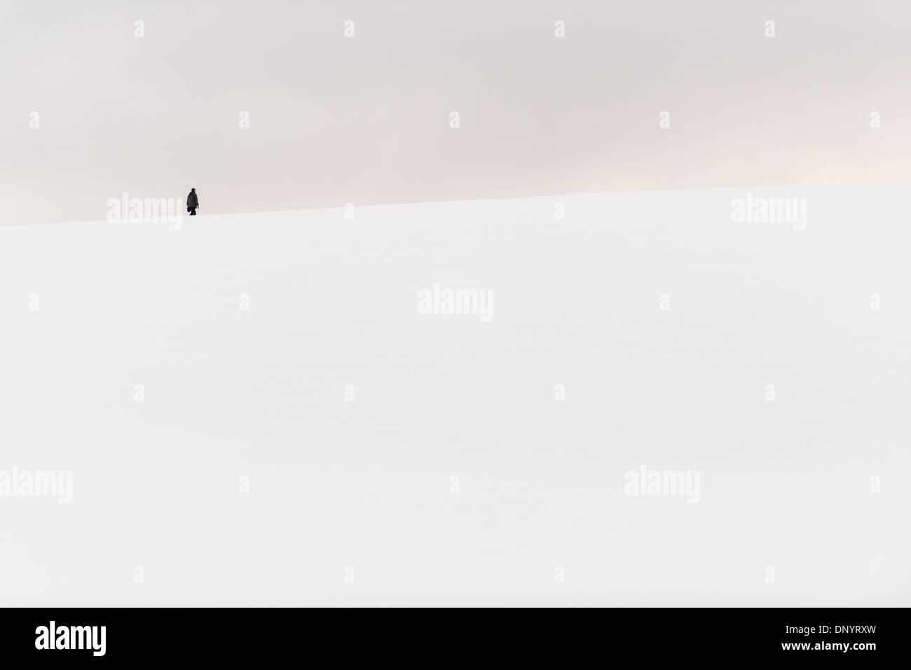 Antarktis - eine Person Wanderungen auf der Spitze eines kleinen verschneiten Hügel in Hughes Bay an der Westküste der Antarktischen Halbinsel. Stockfoto