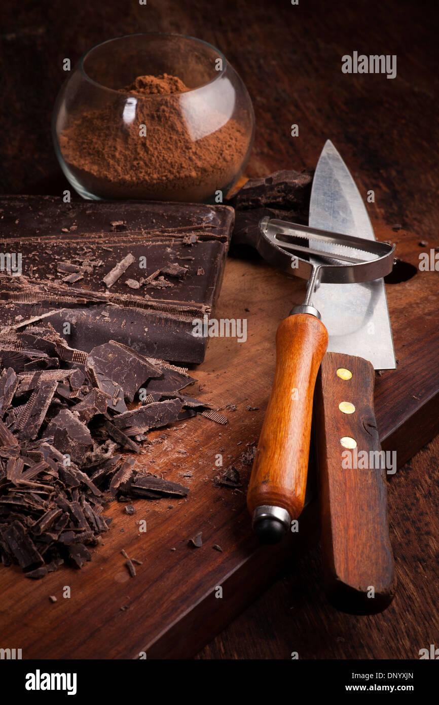 Schneiden von Schokolade und Kakao-Pulver auf einem Holztisch Stockfoto