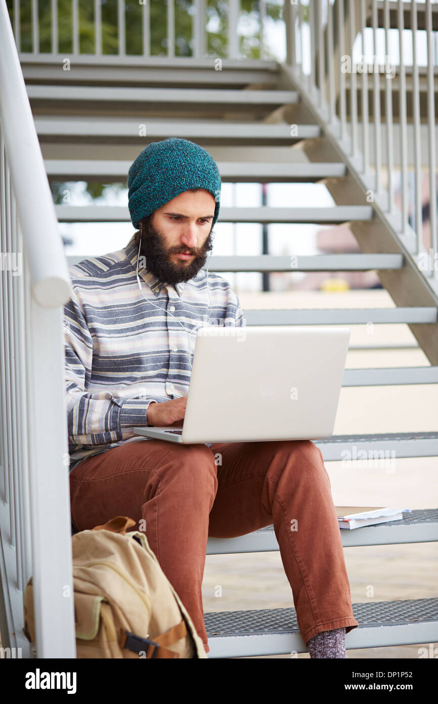Junge bärtige Hipster Student mit Computer am Uni-campus Stockfoto