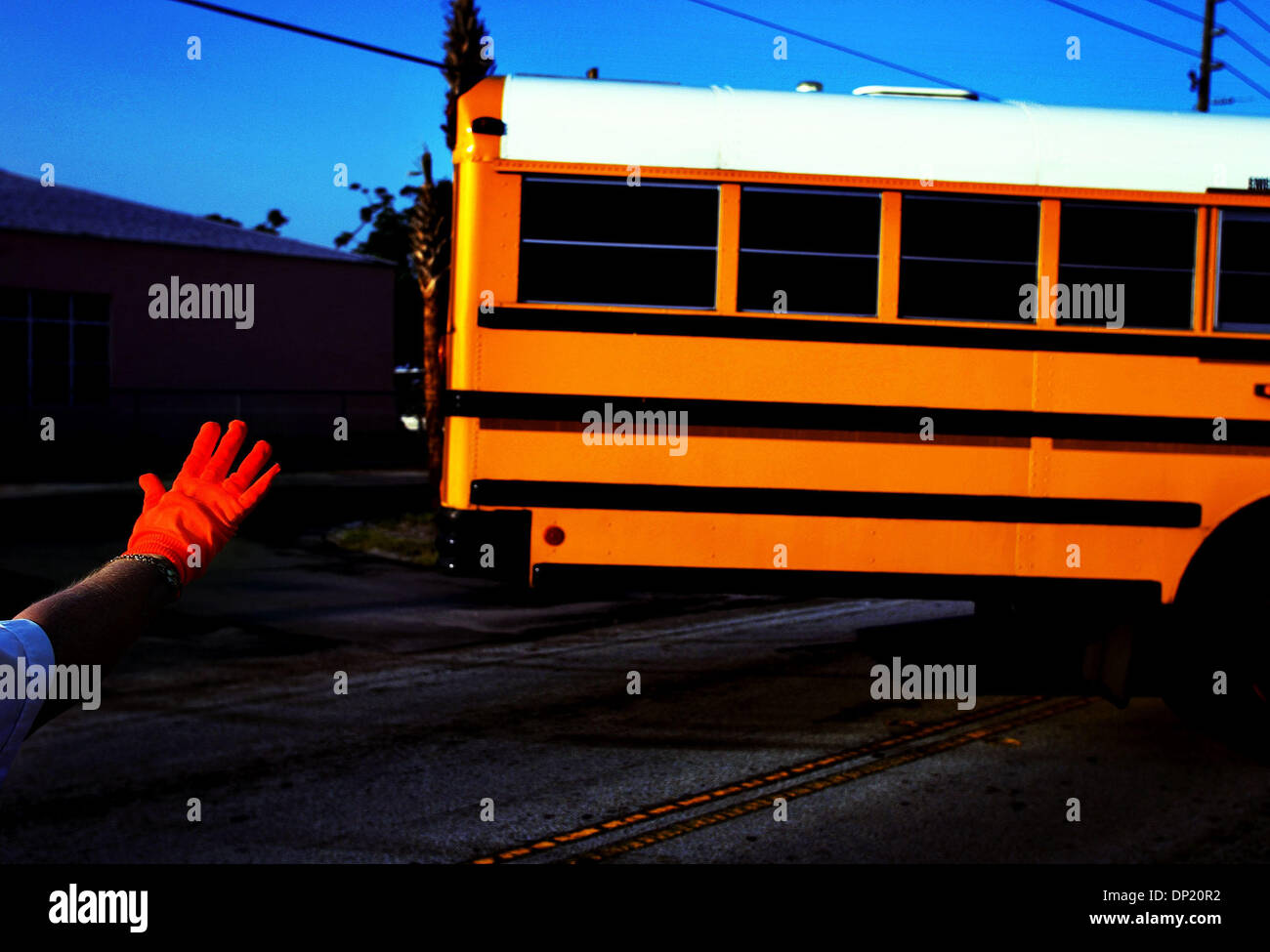 12. Mai 2006; Stuart, FL, USA; Crossing Guard begleitet Fay Dropchuk einen Schulbus in Verkehr frühen Freitagmorgen in Port Salerno. Nach 30 Jahren weht ihr Pfeifen und winken ihr Hand, Gruß Kinder und lächelnd an vorbeifahrende Autofahrer ist Dropchuk Aufhängen ihre Handschuhe und Ausscheiden aus ihrer Kreuzung Wache Pflichten an der Ecke von Salerno Straße und Ebbtide Avenue in Port Salerno. Sie Stockfoto