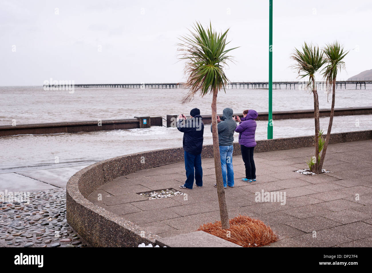 Ramsey, Isle Of Man - 3 Personen mit mobilen Smartphones Überschwemmungen während eine außergewöhnlich hohe Flut zu fotografieren Stockfoto