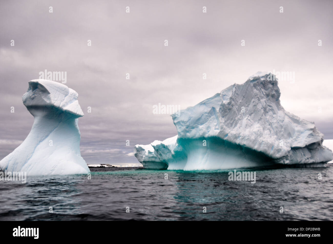 Antarktis - ein Eisberg scheint in zwei geschnitzt zu sein, aber ist unter Wasser verbunden, an zwei hummock Insel auf der Antarktischen Halbinsel. Stockfoto