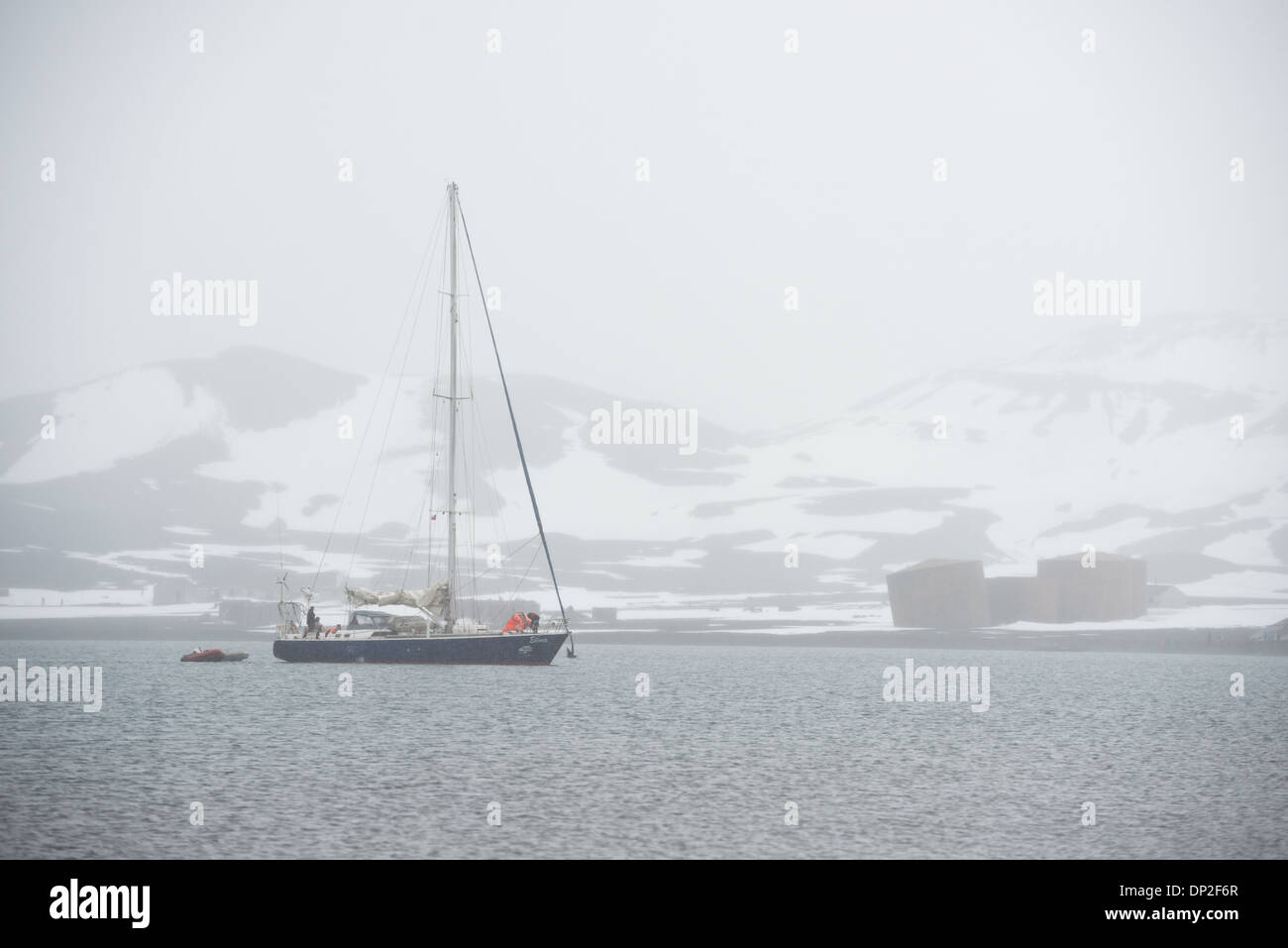 Antarktis - eine Yacht, die Elincia, kommt in der Nähe der Ufer des Whalers Bay auf Deception Island mit Schnee zu verankern. Deception Island, in der South Shetland Inseln, ist eine Caldera des Vulkans und besteht aus vulkanischem Gestein. Stockfoto