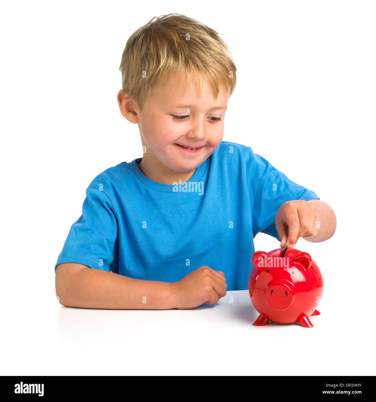 Junge, Geld in ein Sparschwein Stockfoto
