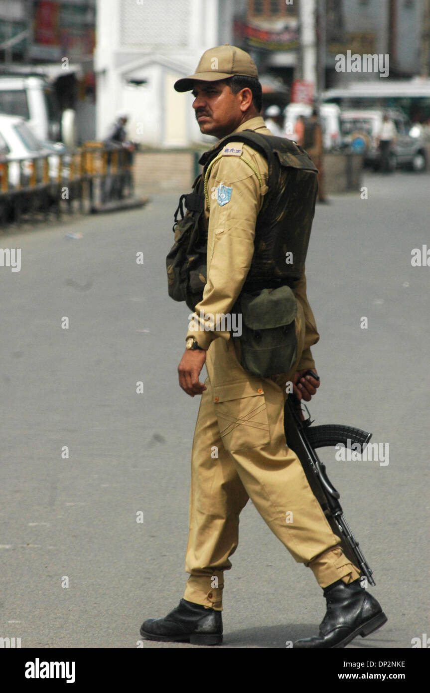 8. Juni 2006; Srinagar, Kaschmir, Indien; Eine indische Paramiltary Soldat steht in Lal Chowk Srinagar, als die Bombe Abgang im Kader (nicht im Bild) eine Blindgänger Granate am Straßenrand inspiziert. Obligatorische Credit: Foto von Altaf Zargar/ZUMA Press. (©) Copyright 2006 von Altaf Zargar Stockfoto