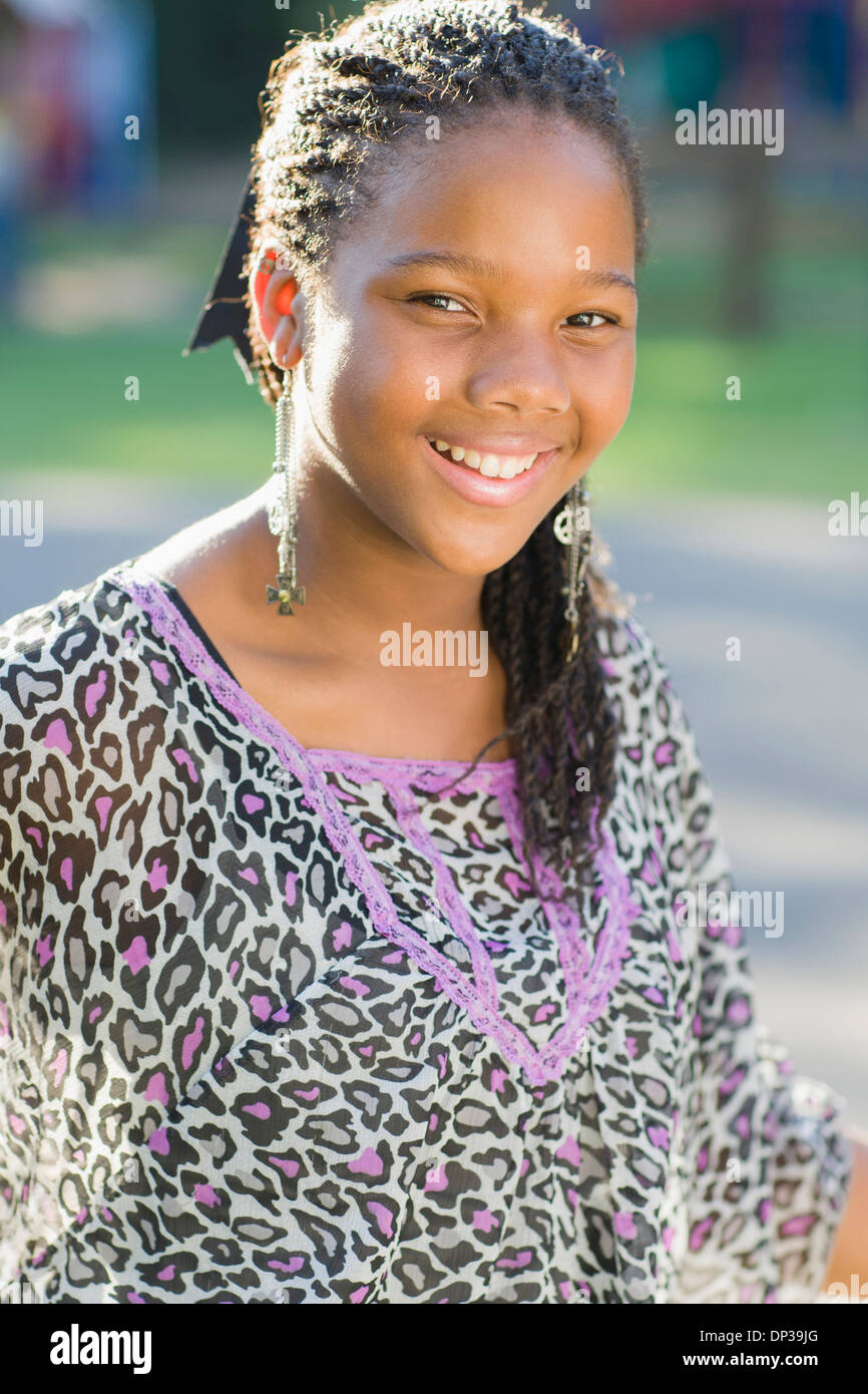 Porträt von pre-teen Mädchen mit langen, schwarzen Haare in Zöpfen, im freien Stockfoto