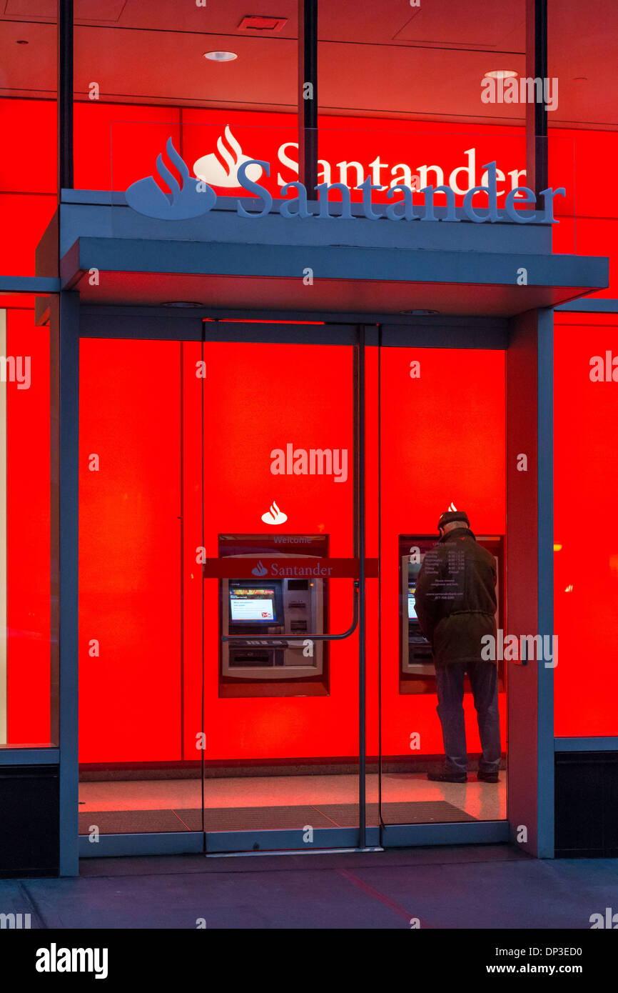 Mann mit ATM bei Banco Santander Filiale in der Abenddämmerung, NYC, USA Stockfoto