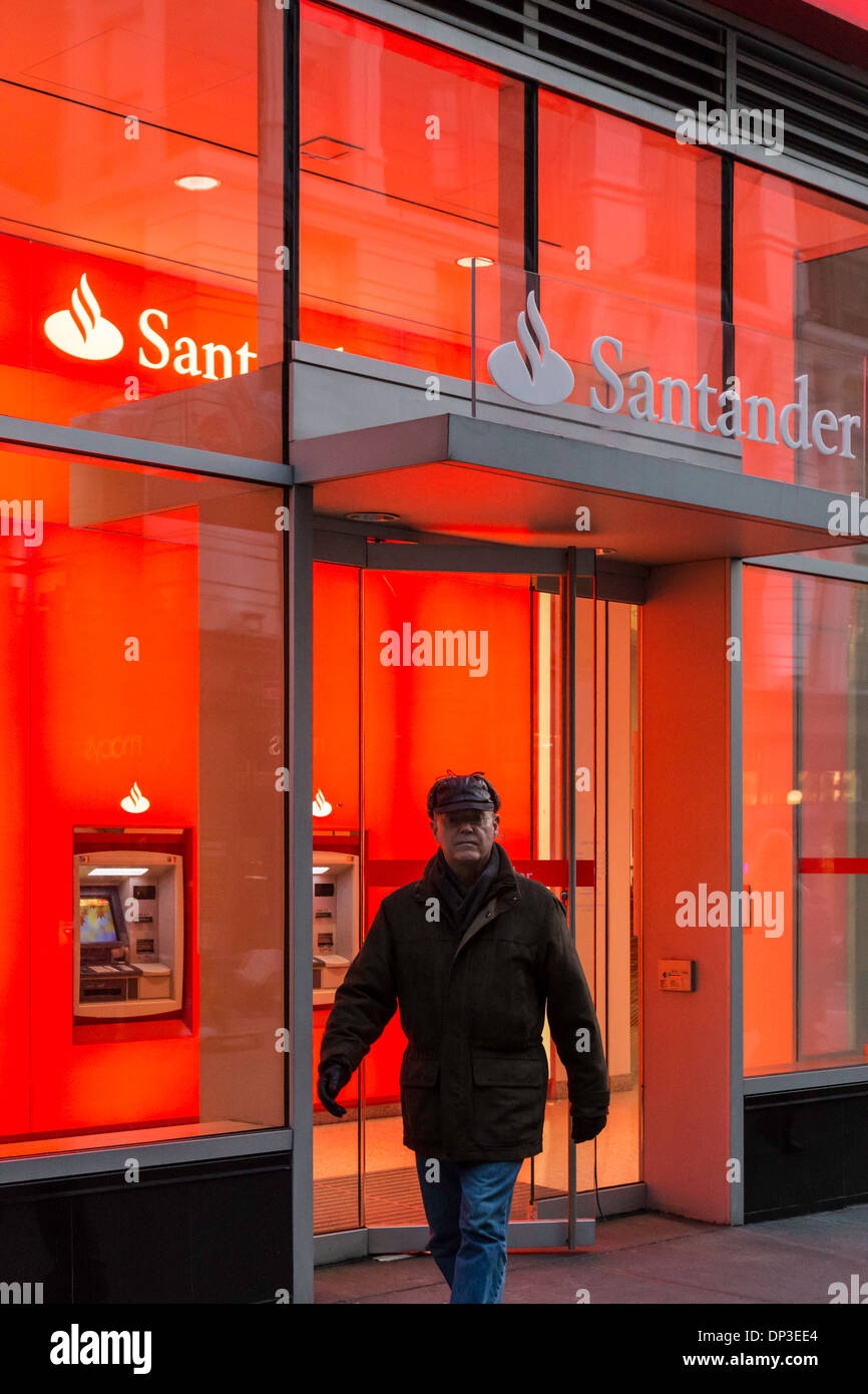 Mann zu Fuß außerhalb Banco Santander Filiale äußere in der Abenddämmerung, NYC, USA Stockfoto