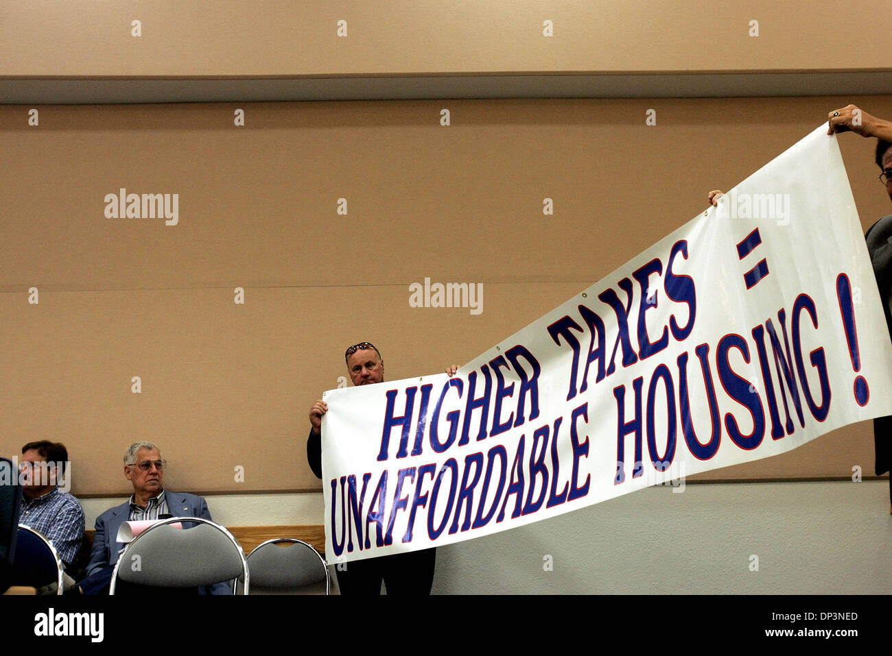 13. Juli 2006; West Palm Beach, FL, USA; Grafschaft Republikaner gehostet stillen Protest während der Grafschaft Budget Workshop am Donnerstag Morgen. John Carroll von Wellington, center, eine Hälfte des Zeichens, die liest "höhere Steuern = unbezahlbar Housing!" Auf der rechten Seite ist Sid Dinerstein Palm Beach Gardens.  Obligatorische Credit: Foto von Libby Volgyes/Palm Beach Post/ZUMA Press. (©) Copyri Stockfoto