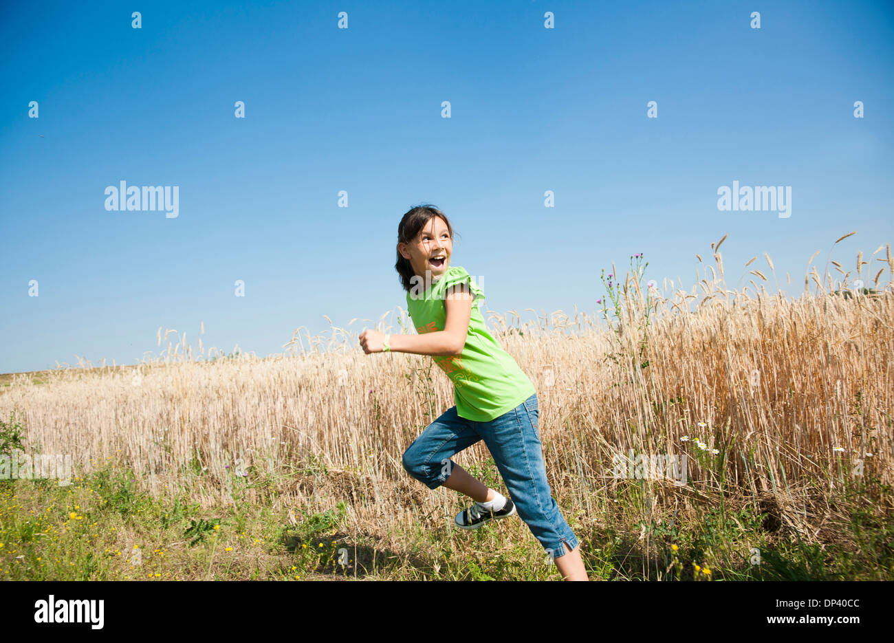 Mädchen im Feld laufen auf Hügel, Deutschland Stockfoto
