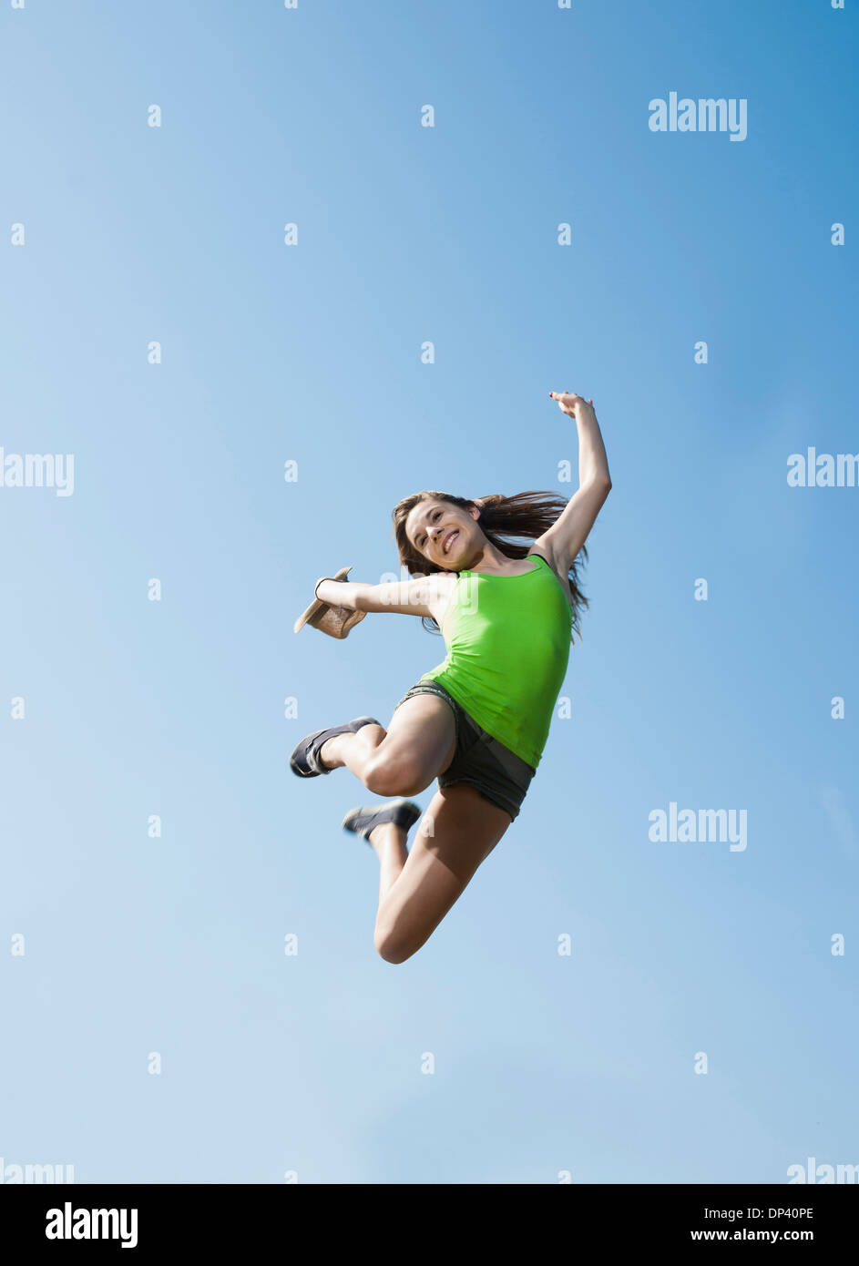 Teenager Mädchen springen in der Luft gegen blauen Himmel, Deutschland Stockfoto