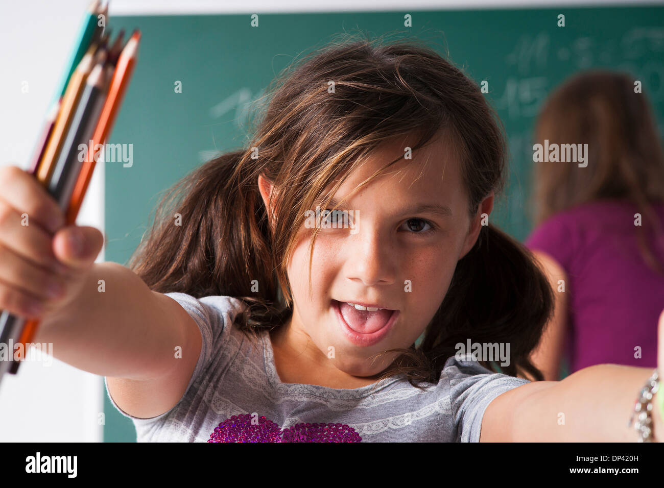 Close-up Portrait von Mädchen im Unterricht, mit Buntstiften in Händen, Deutschland Stockfoto